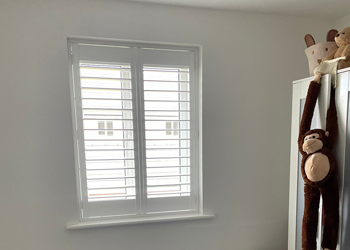 Blackout Shutters in a Child's Bedroom, showing one panel open with the pleated blind visible